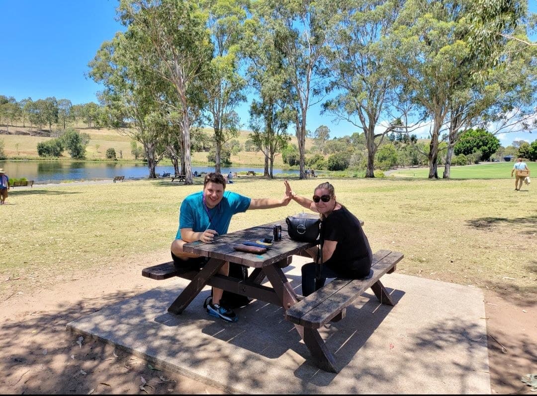 Participants and support workers enjoying an outdoor community picnic